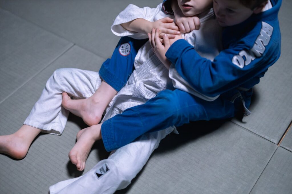 Two young boys training in jiu jitsu, focused on technique and skill development.